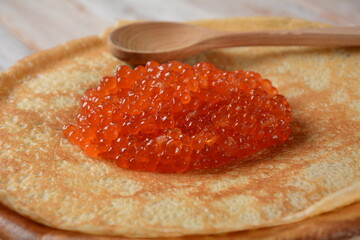 Pancakes with red caviar. Shrovetide Maslenitsa Week festival meal. Stack of Russian pancakes with...