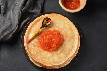 Pancakes with red caviar. Shrovetide Maslenitsa Week festival meal. Stack of Russian pancakes with red caviar. Rustic style
