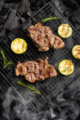 Beef steak on the grill grate, flames on background. Barbecue and grill, delicious food.