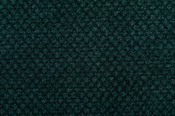Green fabric texture. Furniture upholstery textiles. Embossed pattern. Woven fibers. The material is soft touch. Minimalism concept. High detail macro photography for backgrounds or wallpapers.