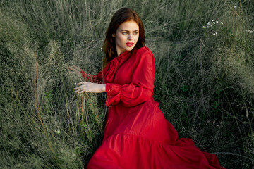 pretty woman in red dress in field nature posing landscape