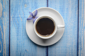 Coffee. White cup of coffee on a blue wooden table.