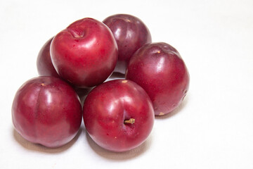 Ripe plum group on white background and selective focus