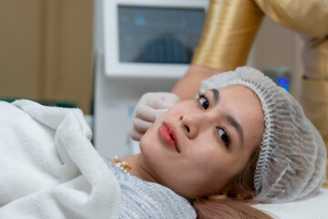 Close up the dermatologist apply the High intensity focus ultrasound to the woman face  for the facial treatment, rejuvenation and anti-aging.