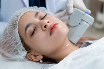 Close up the dermatologist apply the High intensity focus ultrasound to the woman face  for the...