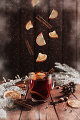 Mulled Wine Christmas cup on table, levitation of cinnamon stick, orange, apple
