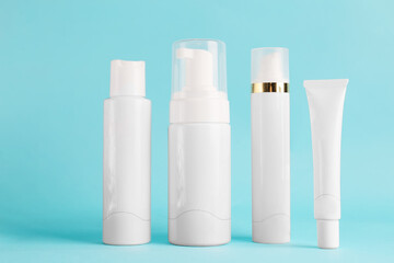 Containers with cosmetics on blue background