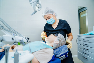 real. dentist examines patient's teeth. regular care and prevention.