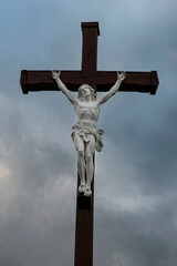 Crucifix of a white stone Jesus Christ on a dark wooden cross