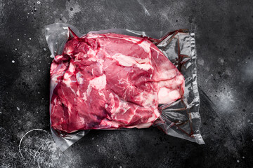 Lamb meat raw pack, on black dark stone table background, top view flat lay, with copy space for...