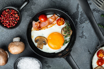 Fried Egg with ingredients in cast iron frying pan, on gray background, top view flat lay