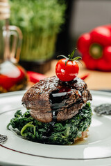 Large grilled Filet Mignon steak with spinach. Grilled meat dish with vegetables, vertical image. top view. place for text