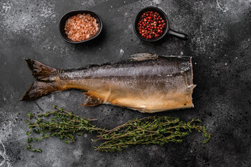 Whole hot smoked fish, on black dark stone table background, top view flat lay