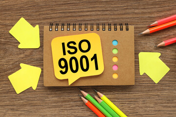 ISO 9001. text on yellow sticker on notepad