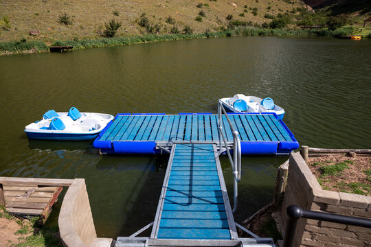 Two paddle boats connected to a floatable jetty on a lake 