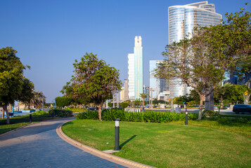 Skyscrapers surrounded by a green park of palm trees on La Corniche promenade in Abu Dhabi, capital of the United Arab Emirates.