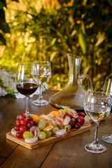Cold platter and wine glasses on a wooden table.