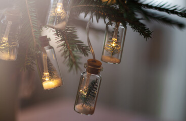 Garland in the form of small Christmas trees in vials. Soft focus