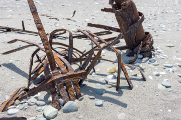metal debris on the seashore in the sand. parts from mechanisms. environmental pollution