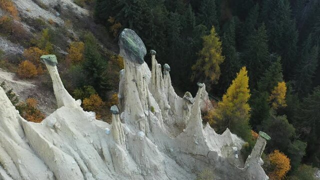 Aerial view on natural Earth Pyramids of Platten in autumn Dolomite Alps. Perca, Dolomites, Italy. UHD 4k drone video
