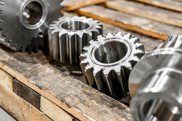 Several spur gears, after CNC processing, lie on the beams, close-up.