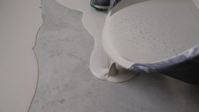Leveling with a mixture of cement floors. Finishing work - the worker does the bulk floor. Self-leveling epoxy.