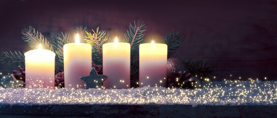 Four burning advent candles and luminous lights.