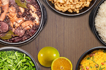 Typical Brazilian feijoada food in top view with the typical accompaniments