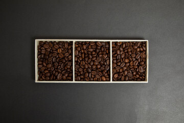 a wooden box full of coffee beans. Black background.
