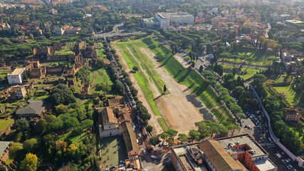 Fototapeta premium Aerial drone photo of iconic Circus Maximus a green space and remains of a stone - marble arena used for chariot races built next to Palatine hill and world famous Colosseum, historic Rome, Italy