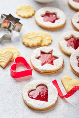 Classic Linzer Christmas Cookies with raspberry or strawberry jam on light background.