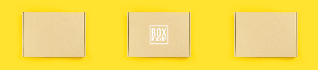 Cardboard box mockup, shipping and delivery concept. Banner, yellow table background. Suitable for food, cosmetic or medical packaging