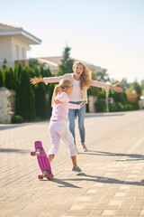 Fototapeta premium A blonde girl trying skateboarding and feeling excited