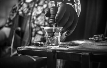 Hand of professional tattoo artist and a tattoo machine.