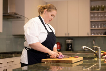 Professional Chef Megan Gill in home kitchen cutting a radish on cutting board 
