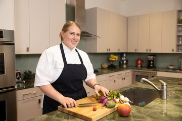 Portrait of Chef Megan Gill in home kitchen looking at camera smiling with pride.