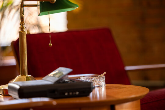 Home Interior, detail of side table with vintage tape recorder / answering machine and ashtray that has a lit CBD pre-roll joint, cigarette with smoke rising