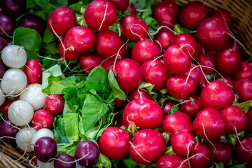 Looking down on a basket of colourful radishes on a market stall