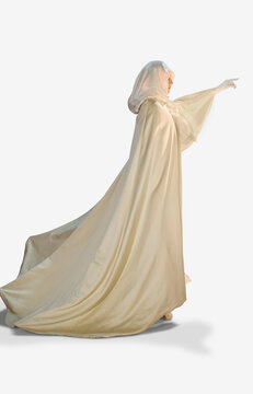 Portrait Of A Woman Dressed As A Ghost For Halloween Turned Profile With One Arm Reaching Out , Against A White Background