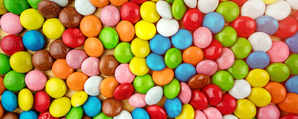 Fototapeta na wymiar Background of multicolored sweet candy assorted on table surface