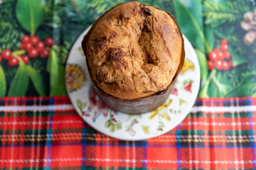 Italian Panettone on a table with a tablecloth decorated for Christmas, in close-up photo and top view