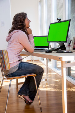 Smiling young woman on a video call in home office.