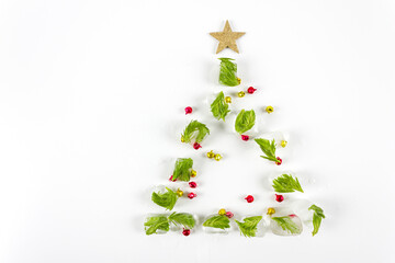 Creative Christmas tree shape made with melting ice on white background. Minimal holiday concept. Flat lay. Copy space.