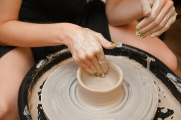 Fototapeta premium potter, clay, workshop, Woman's hands making pottery circle top view
