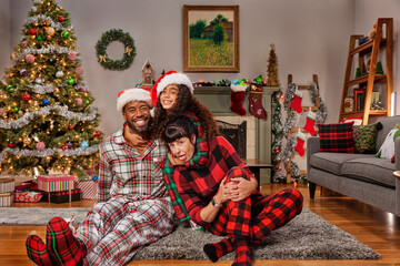 Multi racial family gathered in living room celebrating Christmas.