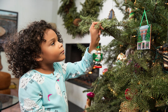 Little girl decorating Christmas tree.