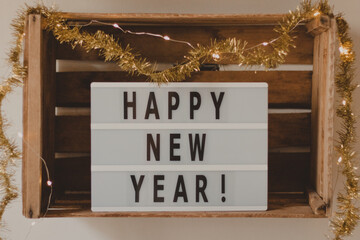 happy new year light box in a wooden box decorated with gold ornaments
