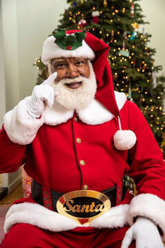Representation of a African American Black Santa Claus, pointing at camera. 
