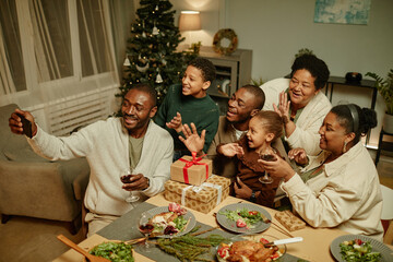 Portrait of happy African-American family taking selfie photo while enjoying Christmas together