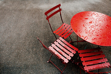 Raindrops on outside red metal table and chairs